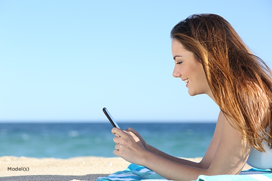 woman looking at her phone on the beach